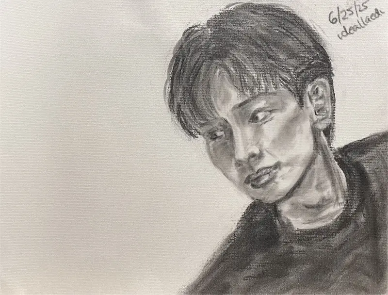 Black and white pan pastel portrait of a young man at the corner of the image gazing at the empty space towards his right